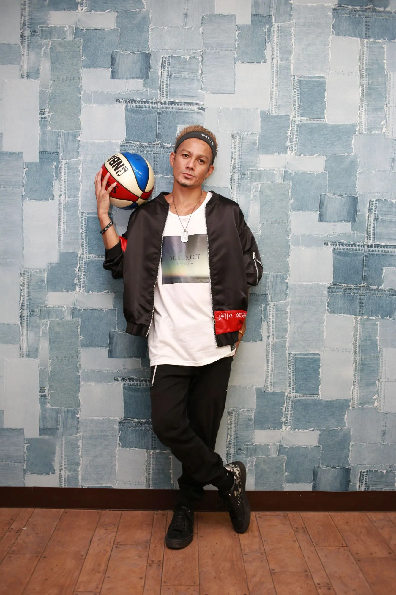 PERFORMER JJ standing with a basketball on his shoulder